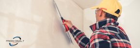 ein Stuckateur, der eine Wand verputzt